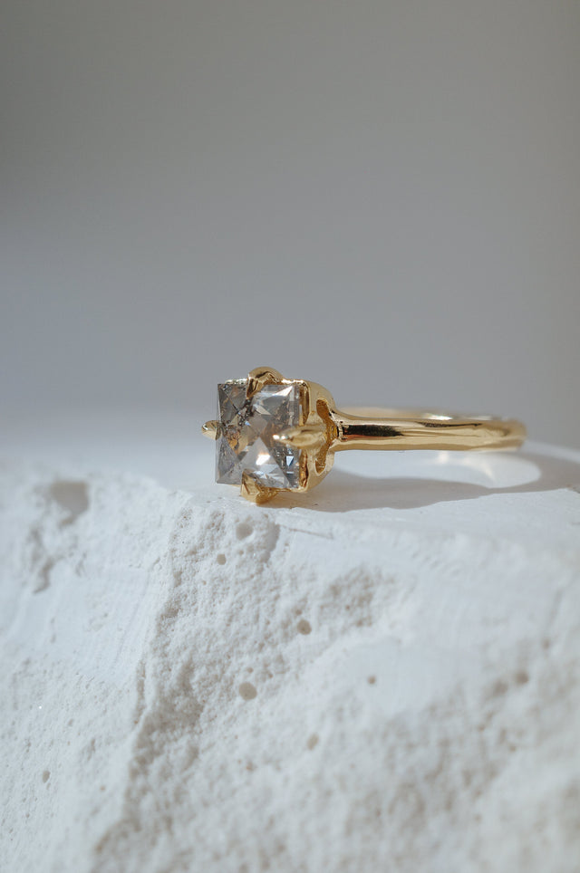 Square speckled grey antique cut diamond. In a hand carved yellow gold basket.