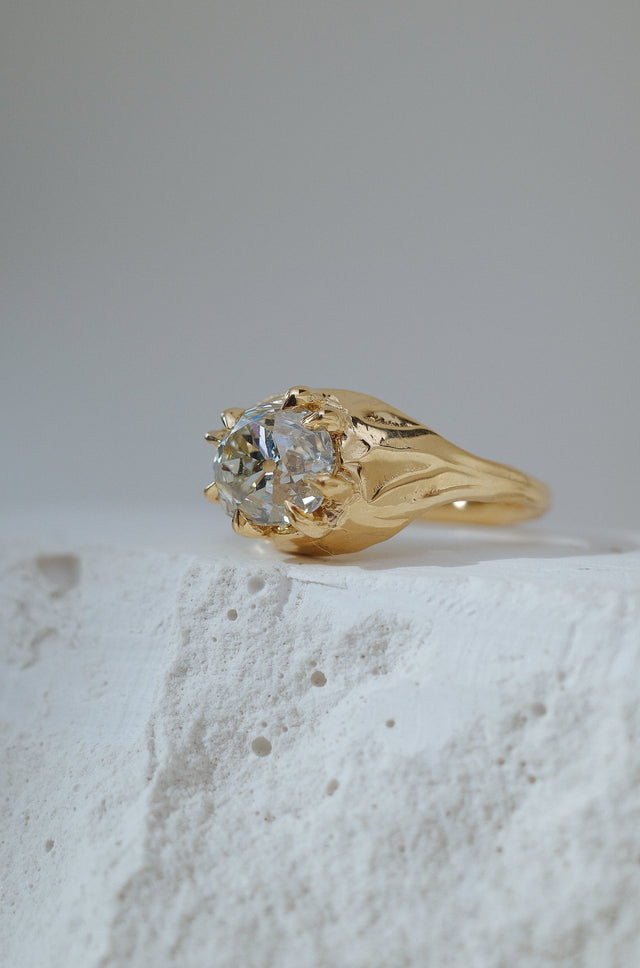 Big chunky ring with swirls of gold surrounding and large, oval, antique diamond.